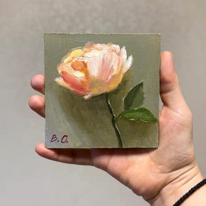 May include: A small painting of a single peach-colored rose with green leaves on a green background. The painting is signed "B.O."