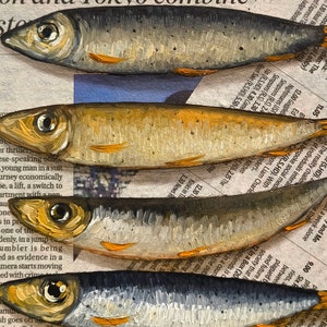 May include: A close-up of five silver and gold fish painted on a newspaper background. The fish are stacked on top of each other, with the tails of the fish at the bottom of the image and the heads of the fish at the top of the image.