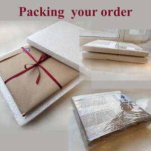 May include: A brown paper package is wrapped with a red ribbon and placed inside a white styrofoam box. The box is being closed. The package is being prepared for shipping.