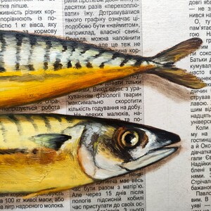 May include: Close-up of two painted fish with yellow and silver scales, set against a backdrop of newspaper text. The fish are detailed with visible eyes and fins, showcasing an artistic rendering of marine life.