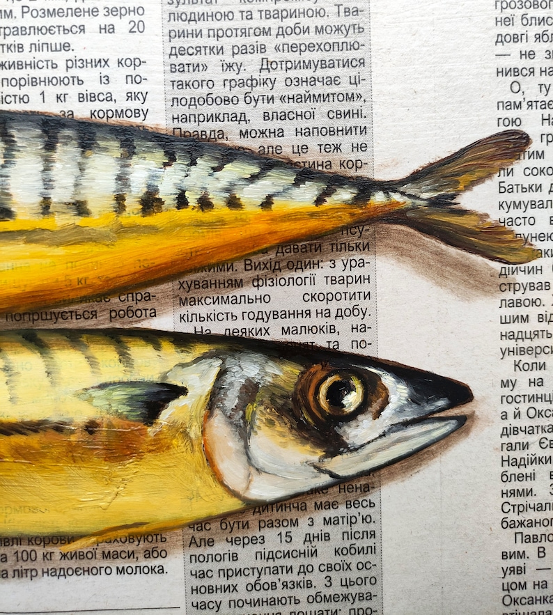 May include: Close-up of two painted fish with yellow and silver scales, set against a backdrop of newspaper text. The fish are detailed with visible eyes and fins, showcasing an artistic rendering of marine life.