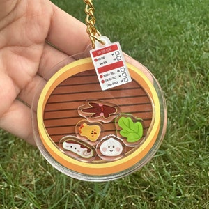 Cute Dim Sum Shaker Keychain with bao, chicken feet, rice roll, siu mai, shuimai, and lettuce charms in bamboo steamer