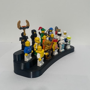 May include: A black plastic display stand with 13 miniature Lego figures. The figures are in various colors and poses, including a knight, a pirate, a ninja, and a robot.