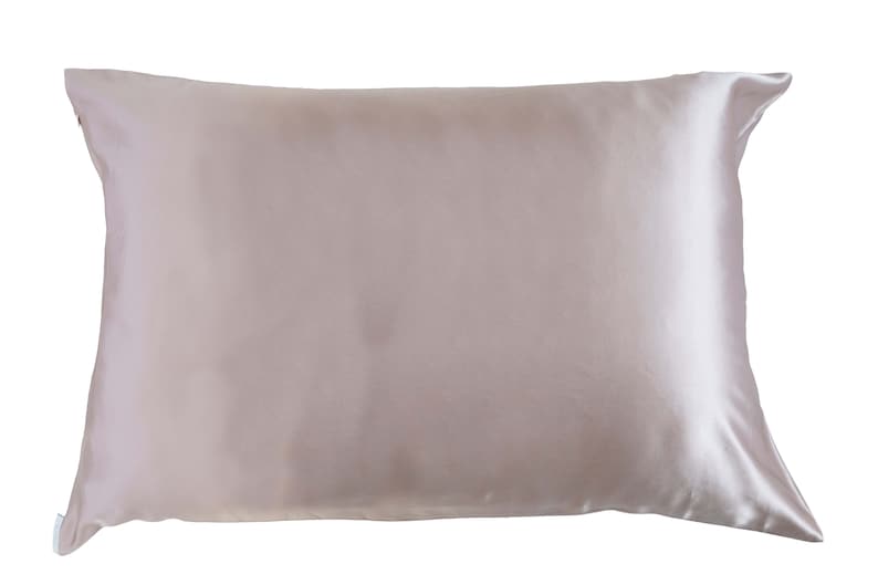 May include: A light pink satin pillowcase. The pillowcase is smooth and wrinkle-free.