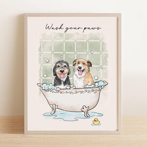 May include: Framed art print featuring two dogs in a bathtub with bubbles. The artwork has a watercolor style, with the text "Wash your paws" at the top. A yellow rubber ducky is at the bottom.
