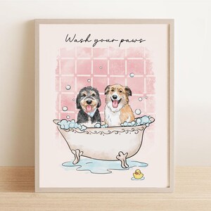 May include: A framed print featuring two dogs in a bathtub with bubbles. The text "Wash your paws" is above the dogs. The background is pink with a grid pattern, and a yellow rubber duck is at the bottom.