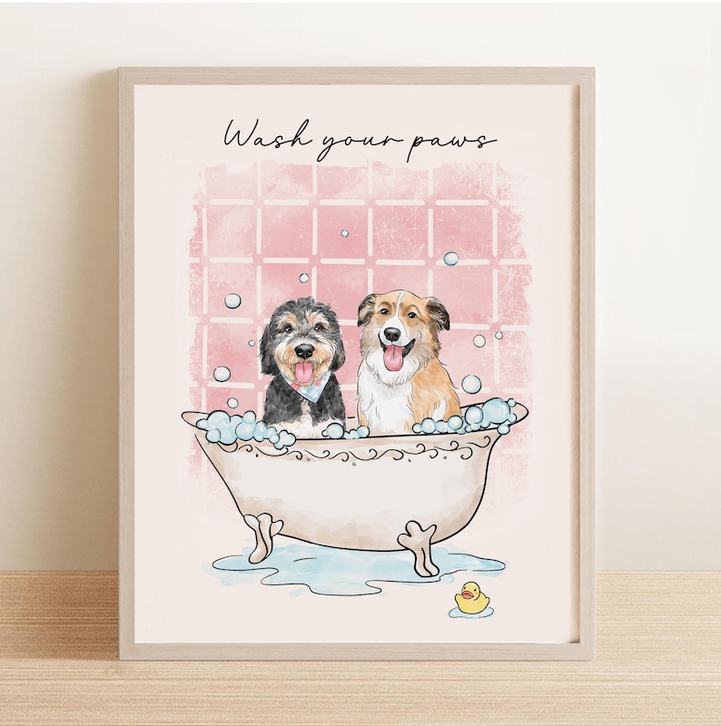 May include: A framed print featuring two dogs in a bathtub with bubbles. The text "Wash your paws" is above the dogs. The background is pink with a grid pattern, and a yellow rubber duck is at the bottom.