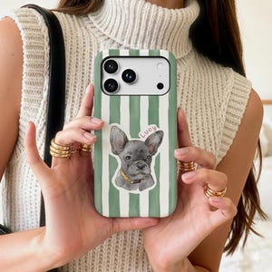 May include: Green and white striped phone case featuring a watercolor illustration of a gray French Bulldog with a yellow collar. The name "Lucy" is written above the dog. The case has a camera cutout.