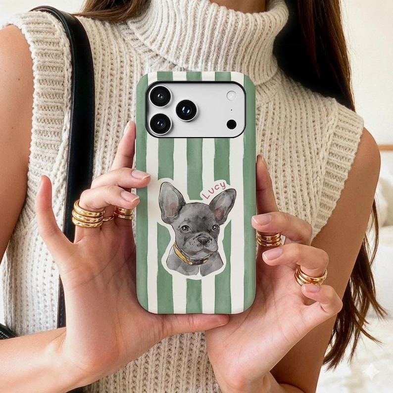 May include: Green and white striped phone case featuring a watercolor illustration of a gray French Bulldog with a yellow collar. The name "Lucy" is written above the dog. The case has a camera cutout.
