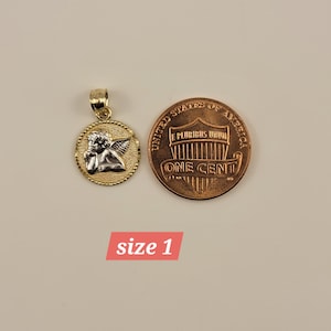 May include: Gold and silver angel pendant charm, shown next to a US penny for size comparison.  The pendant features a detailed angel with wings and a halo.