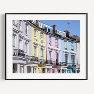 May include: A row of colorful Victorian townhouses with white trim and black balconies. The houses are painted in shades of yellow, pink, blue, and lavender.