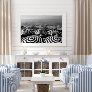 Black and white beach print featuring striped beach umbrellas taken in Nice, France along the Cote dAzur.