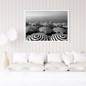 Black and white beach print featuring striped beach umbrellas taken in Nice, France along the Cote dAzur.