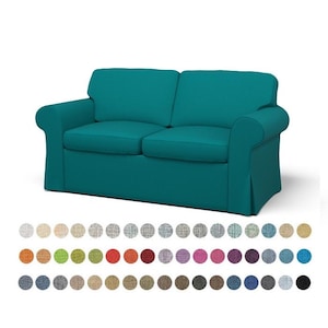 May include: A teal blue sofa with a tufted back and rolled arms. The sofa is covered in a fabric upholstery. The image shows a variety of fabric swatches in different colors and patterns.