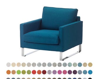May include: A teal armchair with a square design, featuring a cushioned seat, back, and armrests. The chair has a modern aesthetic with silver metal legs. A color palette of fabric swatches is displayed below the chair.
