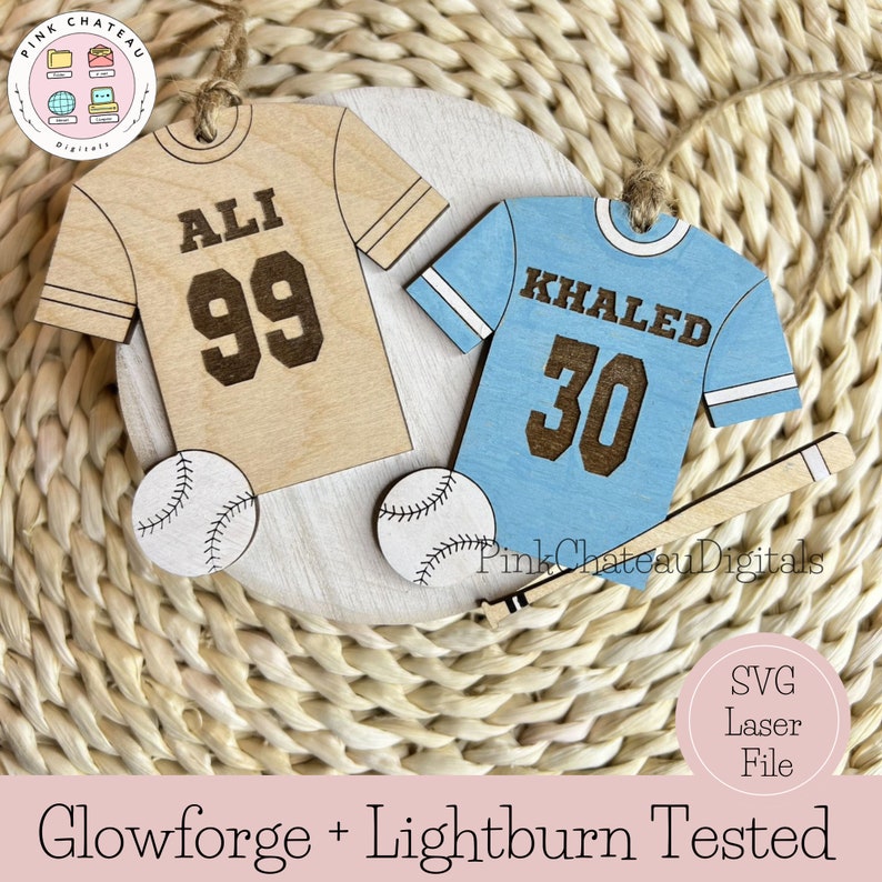 Puede incluir: Dos adornos de camiseta de b&eacute;isbol de madera con pelotas de b&eacute;isbol y un bate. Las camisetas son beige y azul claro con los nombres "ALI 99" y "KHALED 30" en ellas.