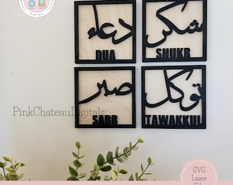 Può includere: Quattro cartelli quadrati in legno con cornice nera con calligrafia araba e le parole in inglese "Dua", "Shukr", "Sabr" e "Tawakkul" su una parete bianca.