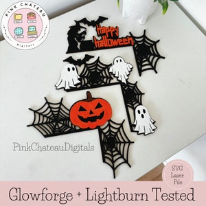 Op de afbeelding: Een set Halloween-thema SVG-snijbestanden met een pompoen, geesten, vleermuizen en spinnenwebben. De tekst "Happy Halloween" is inbegrepen in het ontwerp. Deze bestanden zijn compatibel met Glowforge en Lightburn.