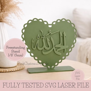 May include: A sage green heart-shaped freestanding stand with scalloped edges, featuring Arabic calligraphy. The stand is 1/8 inch (3mm) thick and sits on a rectangular base. The text "FULLY TESTED SVG LASER FILE" is at the bottom.