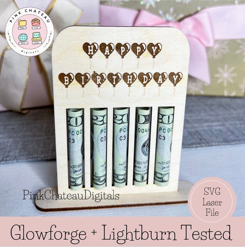 May include: A wooden birthday money holder with the words "Happy Birthday" spelled out with heart-shaped balloons. The holder has five slots for rolled up bills. The holder is made of natural wood and has a light brown color.