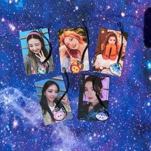 May include: Five colorful photo cards with black lanyards and charms. Each card features a different woman with a different background. The charms are shaped like cartoon cats.