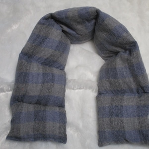 May include: A gray and blue plaid fabric neck wrap. The fabric is soft and has a quilted texture.