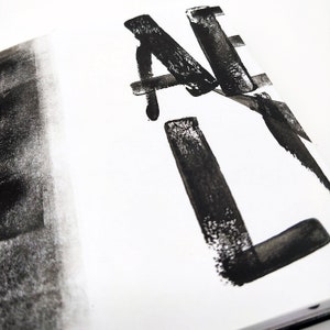 Könnte beinhalten: Schwarze Tintenpinselstriche auf weißem Hintergrund. Die Striche bilden die Buchstaben "A" und "L" in einer stilisierten Schrift.