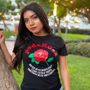 May include: Black t-shirt featuring a red rose graphic with the text "Pode Rosa" above the rose. The text below the rose reads "Mujer inteligente, bouta y con estilo propio. Contenido neto 100% chingona."