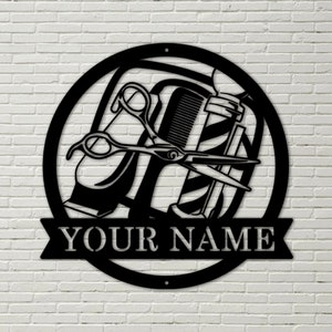May include: Black metal sign with a circular design featuring a barber's pole, scissors, and a razor. The sign has a banner at the bottom with the text "YOUR NAME".