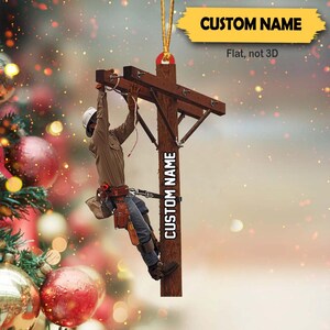 May include: A Christmas ornament featuring a lineman working on a power pole. The ornament is flat and not 3D. The lineman is wearing a hard hat and safety gear. The ornament is personalized with the text "CUSTOM NAME".