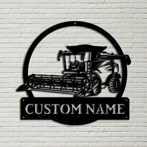 May include: Black metal silhouette of a combine harvester in a circle with the text "CUSTOM NAME" below.