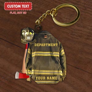 May include: A gold keychain with a firefighter themed charm. The charm features a firefighter jacket with yellow stripes, a firefighter helmet, and an axe. The text "DEPARTMENT" and "YOUR NAME" are printed on the charm.