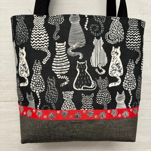 Gatos blancos sobre cartera negra con fondo de vinilo