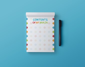 Puede incluir: Un bloc de notas blanco con un patrón de lunares de colores y el texto "CONTENTS OF MY BRAIN:" en la parte delantera. Un bolígrafo negro está acostado al lado del bloc de notas.