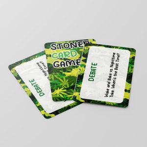 May include: Three green and yellow playing cards with a marijuana leaf pattern. The cards are for a game called "Stoner Card Game". One card has the text "Debate" and the question "Wake and Bake vs. Nighttime Toke: When's the Best Time?"