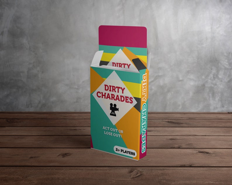 May include: A colorful box of "Dirty Charades" party game. The box features a geometric design with teal, yellow, orange, and pink colors. The game title and a film camera icon are displayed on the front. The text "Act Out or Lose Out!" is also visible.