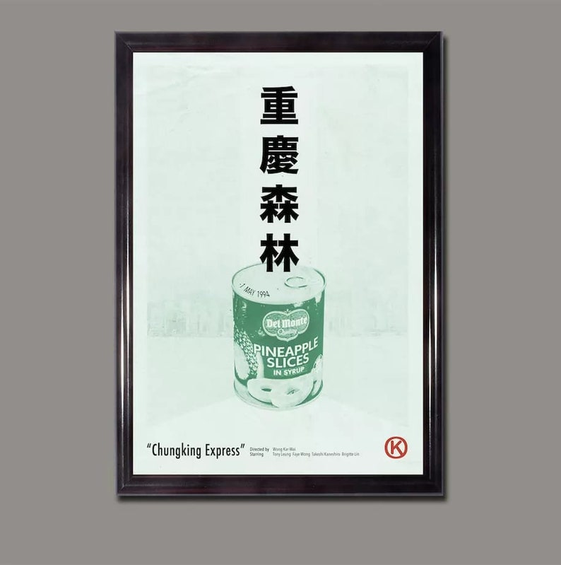 May include: A framed movie poster for the film "Chungking Express" directed by Wong Kar-wai. The poster features a green can of Del Monte pineapple slices in syrup and the Chinese characters for "Chungking Express" in black.