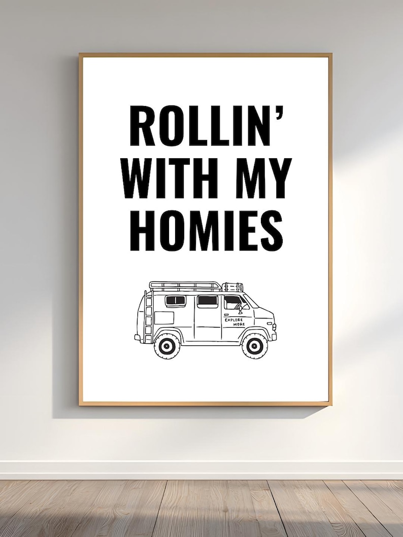 May include: A framed print with the text "ROLLIN' WITH MY HOMIES" in bold black letters above a black and white illustration of a van. The van has a roof rack and the words "EXPLORE MORE" on the side.
