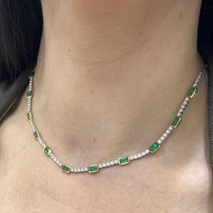 Può includere: Una delicata collana con pietre verdi taglio smeraldo e piccole pietre bianche scintillanti. La collana ha un'incastonatura in oro attorno alle pietre verdi e un'incastonatura in argento per le pietre bianche.
