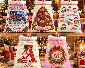 May include: Five white fabric Christmas gift sacks with drawstring closures and pom-poms. Designs include North Pole Air Mail, a photo-ornament tree, a string of lights with faces, a large letter A with Santa, and a wreath with Santa.