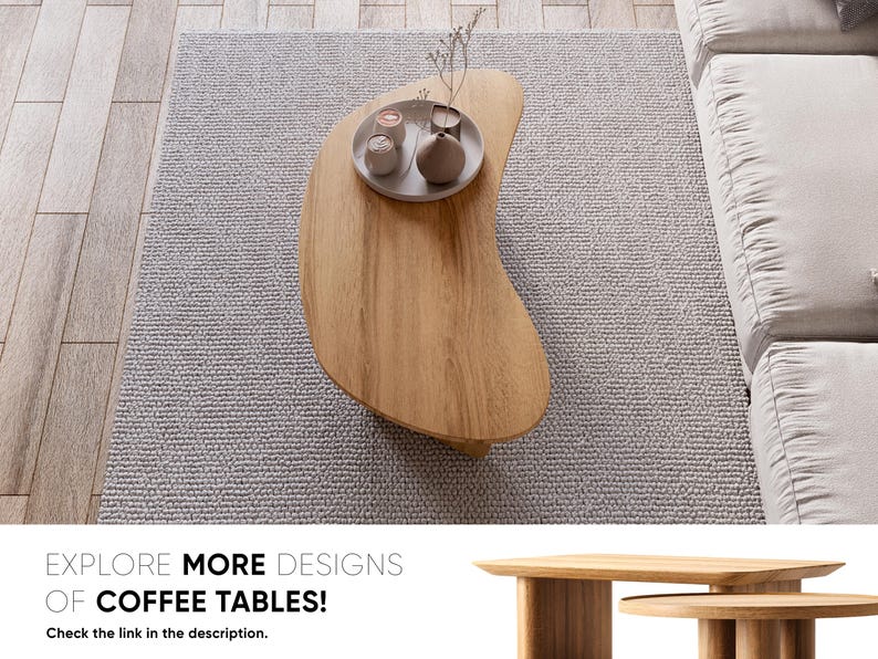 May include: A light brown, organically shaped wooden coffee table with a tray of decorative items. The table sits on a grey rug, near a white sofa. The image includes the text "EXPLORE MORE DESIGNS OF COFFEE TABLES!"