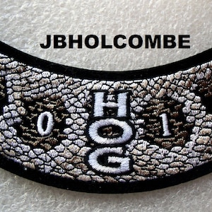 May include: A black and white motorcycle patch with a snakeskin pattern. The patch has the text "HOG" in white and the numbers "2014" in white.
