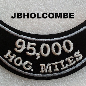 May include: Black motorcycle patch with white embroidered text that reads "95,000 HOG MILES".