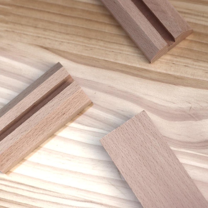 May include: Three pieces of unfinished light brown wood with a groove cut into the center of each piece.