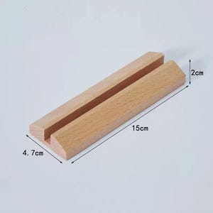 May include: A wooden display stand with a slot for holding cards or photos. The stand is 15 inches long, 4.7 inches wide, and 2 inches tall.