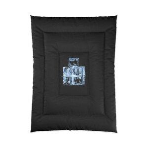 Pode incluir: Edredom preto com um design de cubo de gelo azul e branco que diz "COOL" nele.