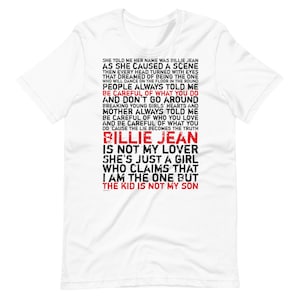 Può includere: Maglietta bianca con testo nero che dice "She told me her name was Billie Jean as she caused a scene... Billie Jean is not my lover she's just a girl who claims that I am the one but the kid is not my son."