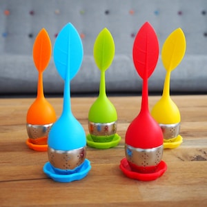 May include: Five colourful silicone tea infusers shaped like leaves with stainless steel mesh strainers. The infusers are orange, blue, green, red and yellow.