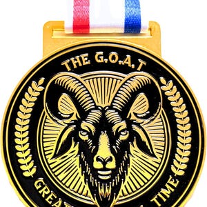 May include: A gold-colored medal with a black and gold ram's head design. The medal has the text "THE G.O.A.T. GREATEST OF ALL TIME" and is suspended by a red, white, and blue ribbon.