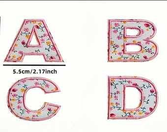Könnte beinhalten: Vier Bügelbilder mit den Buchstaben A, B, C und D. Jeder Buchstabe ist pink mit weißem Hintergrund und einem Blumenmuster. Die Patches sind 5,5 cm / 2,17 Zoll groß.